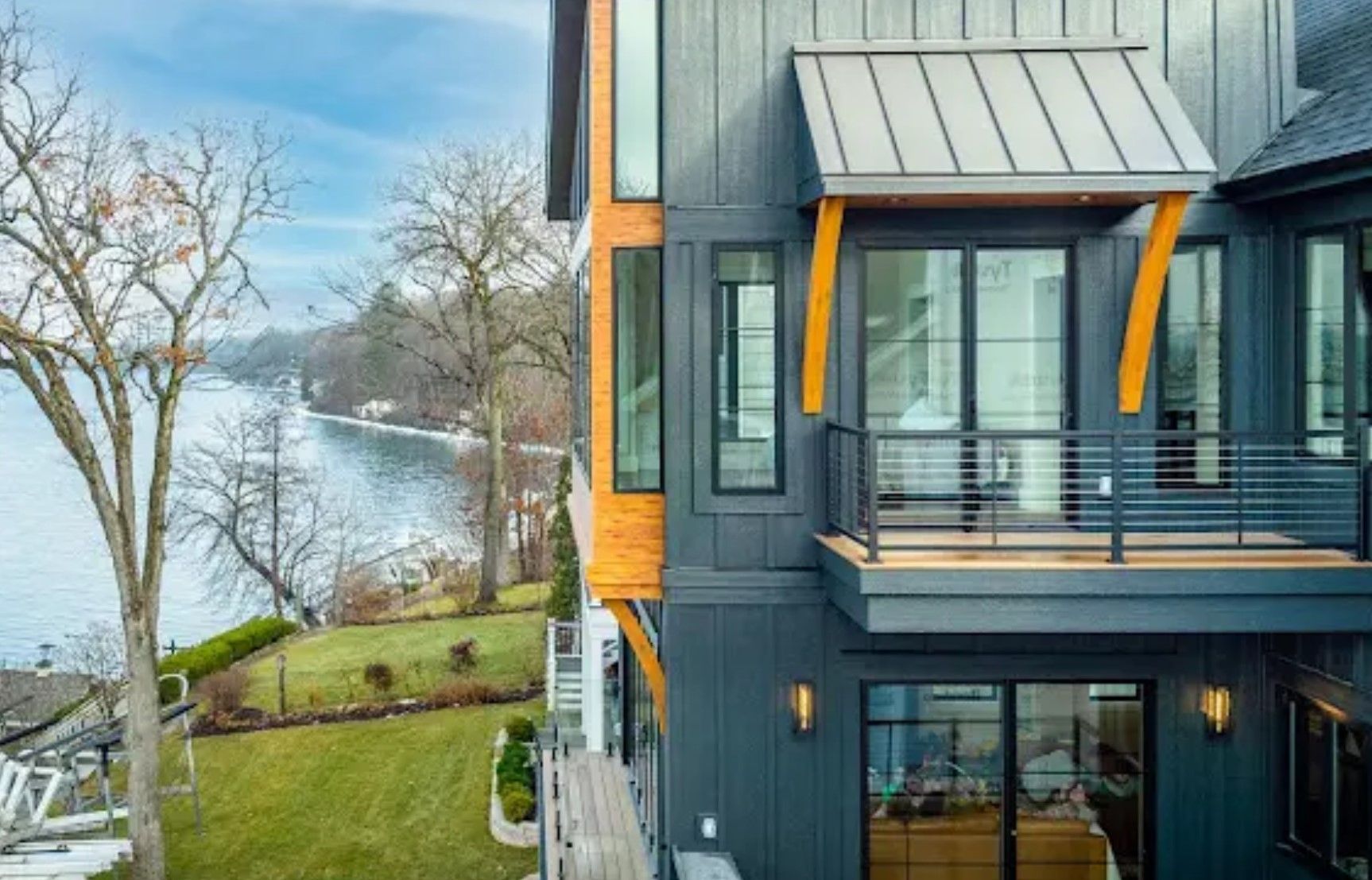 A large house with a balcony overlooking a body of water.