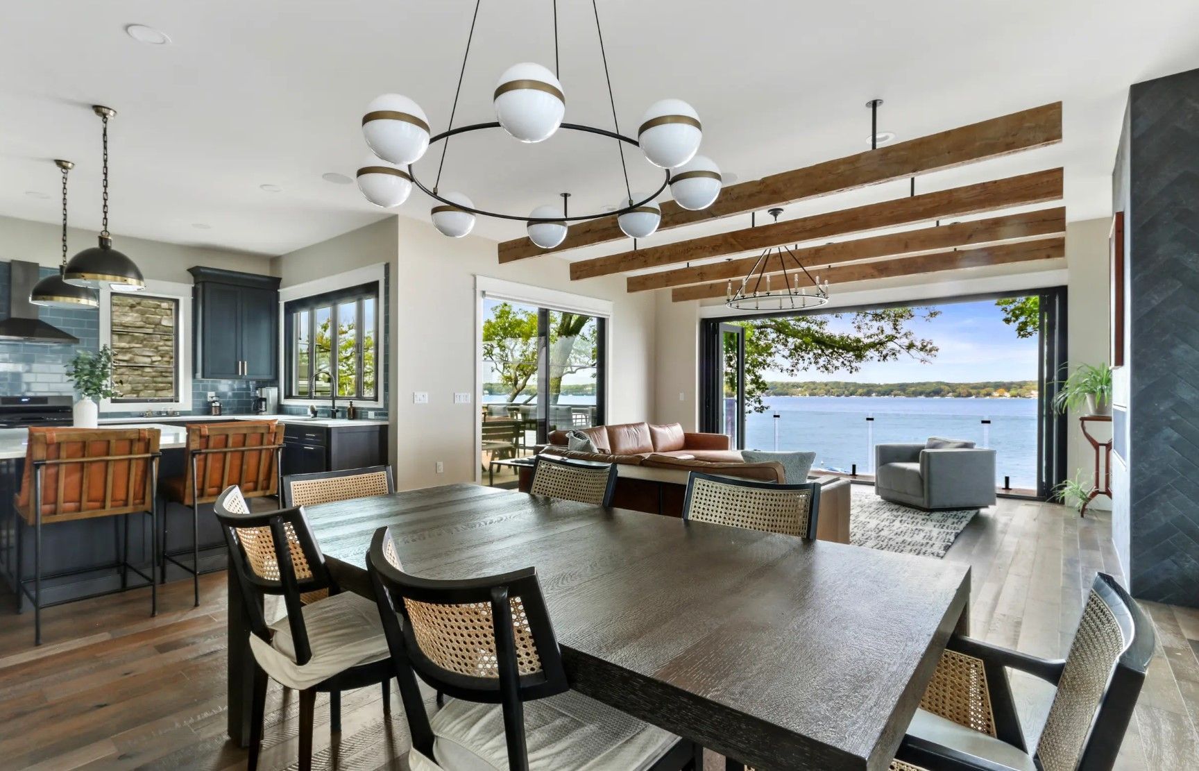 A dining room table and chairs in a house with a view of the water.