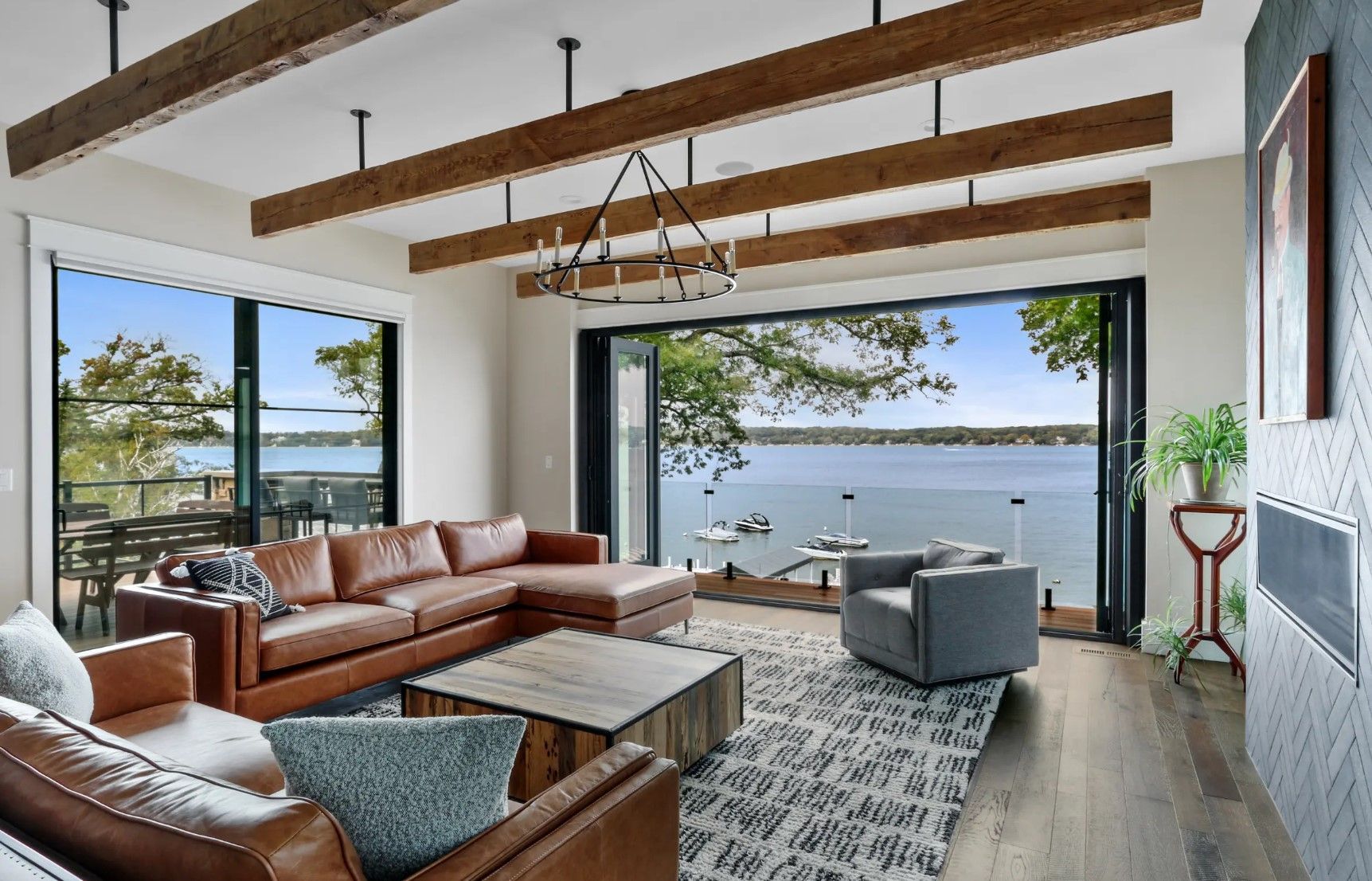 A living room with a couch , chairs , coffee table and a view of a lake.