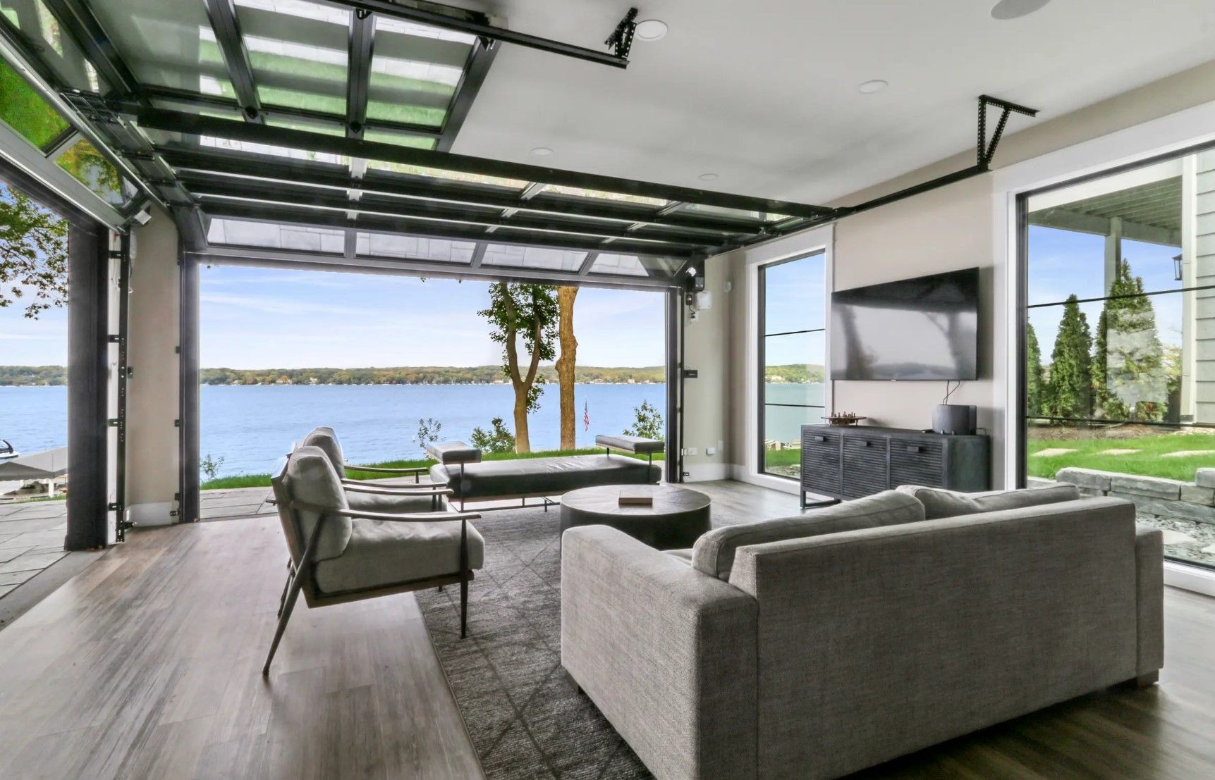 A living room with a couch , chairs , and a flat screen tv.