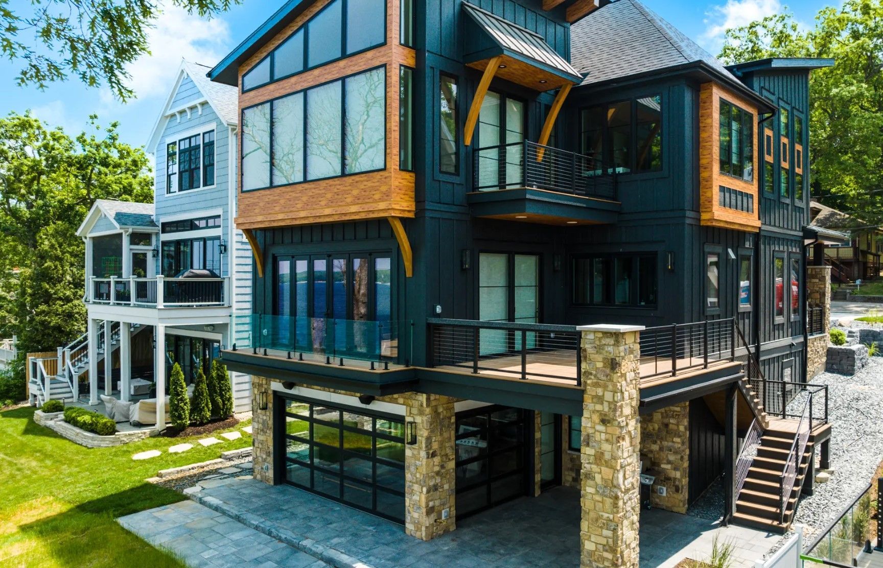 A large house with a lot of windows is sitting on top of a lush green hillside.