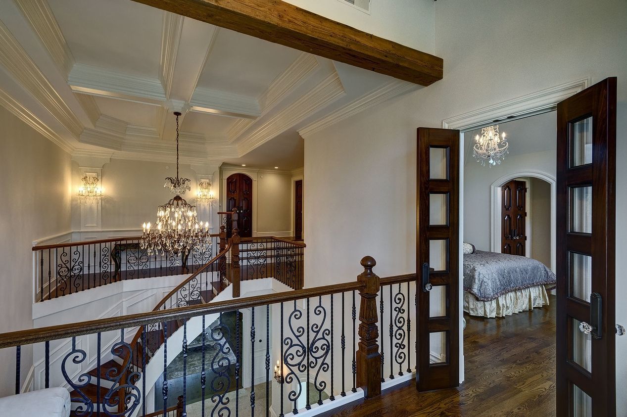 A staircase in a house with a chandelier hanging from the ceiling.