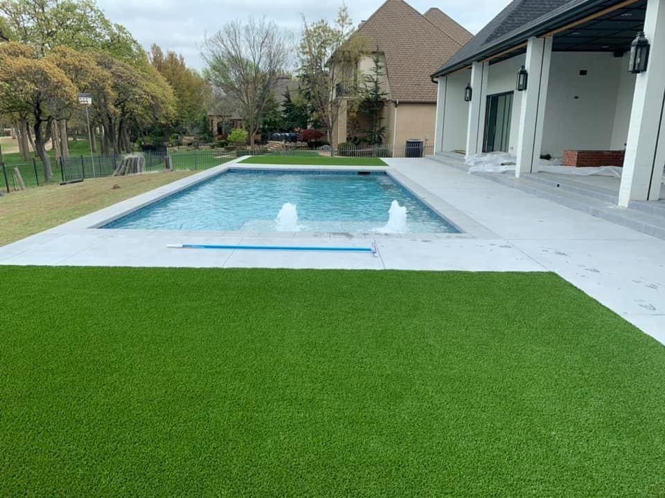 There is a large swimming pool in the backyard of a house.