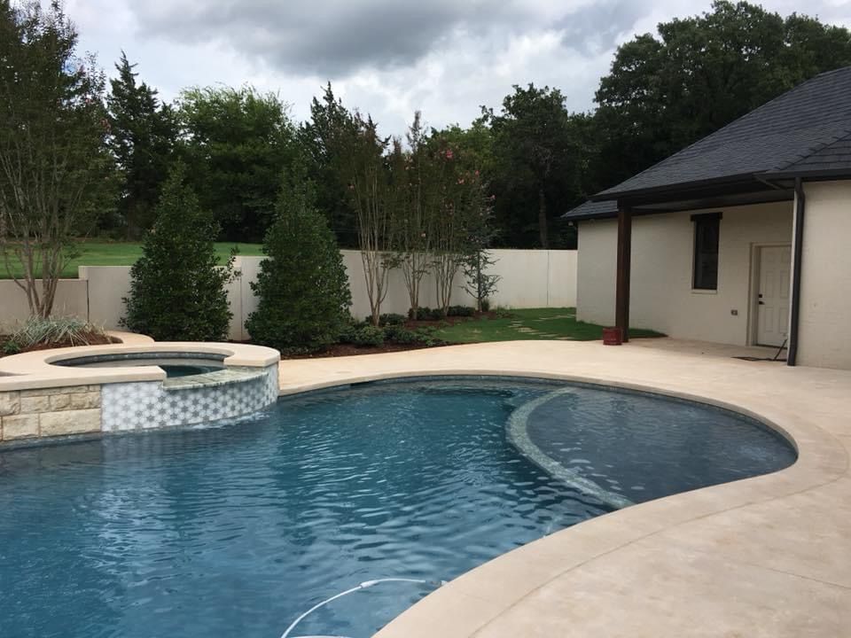 A large swimming pool with a house in the background