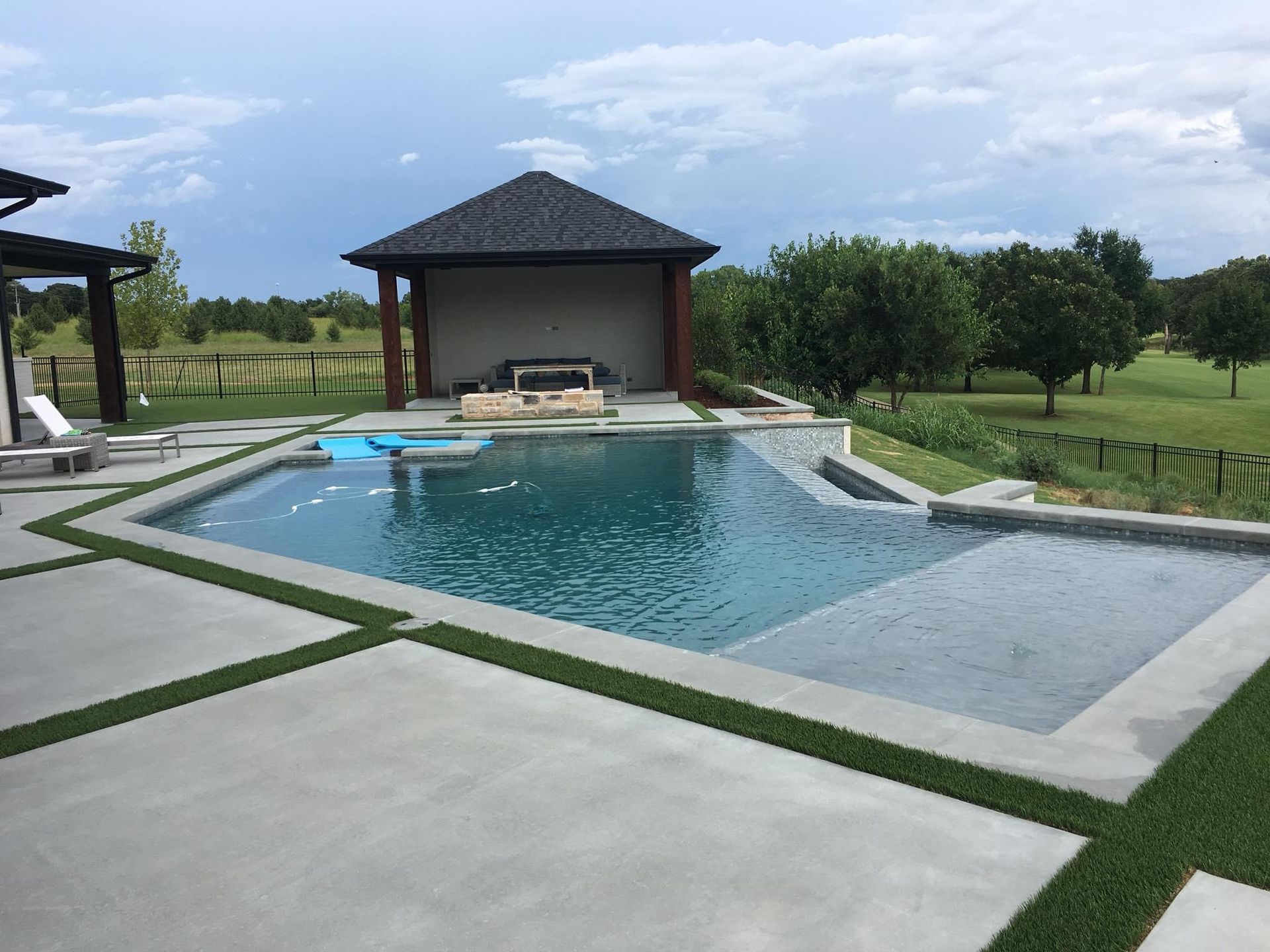 A large swimming pool with a gazebo in the background