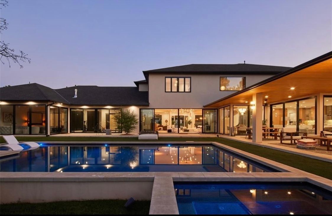 A large house with a large swimming pool in front of it