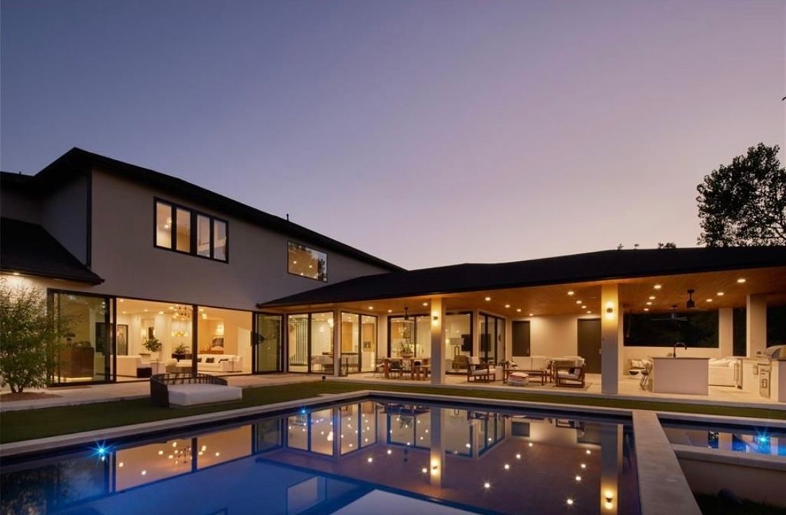 A large house with a large swimming pool in front of it