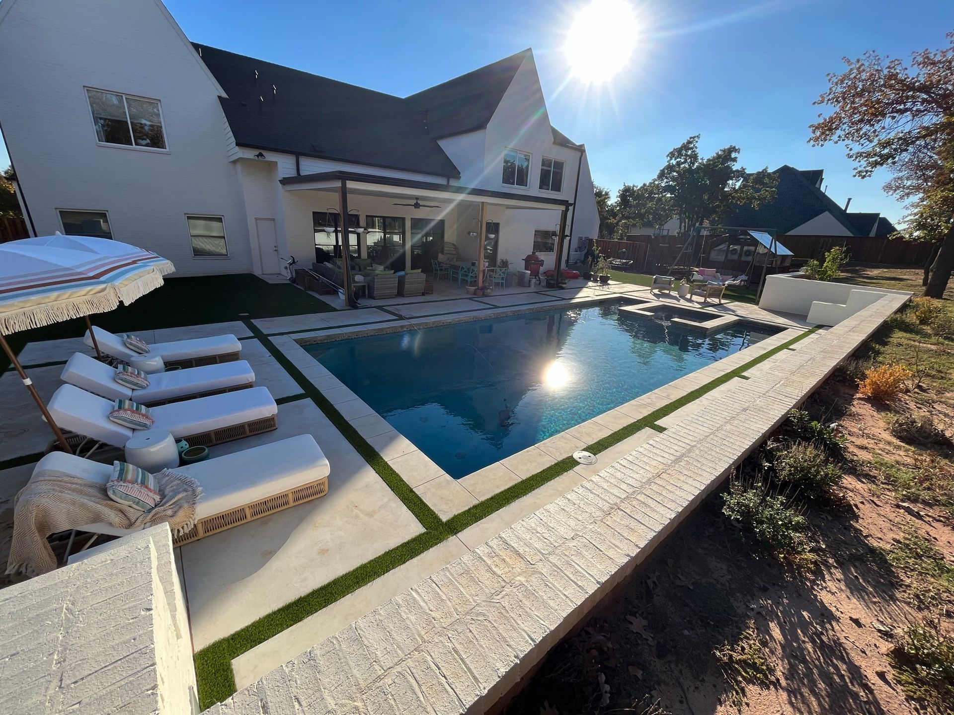 A large white house with a large swimming pool in front of it