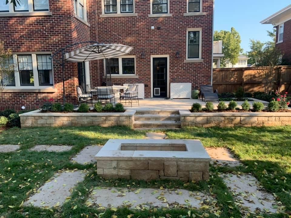 There is a fire pit in the backyard of a brick house.