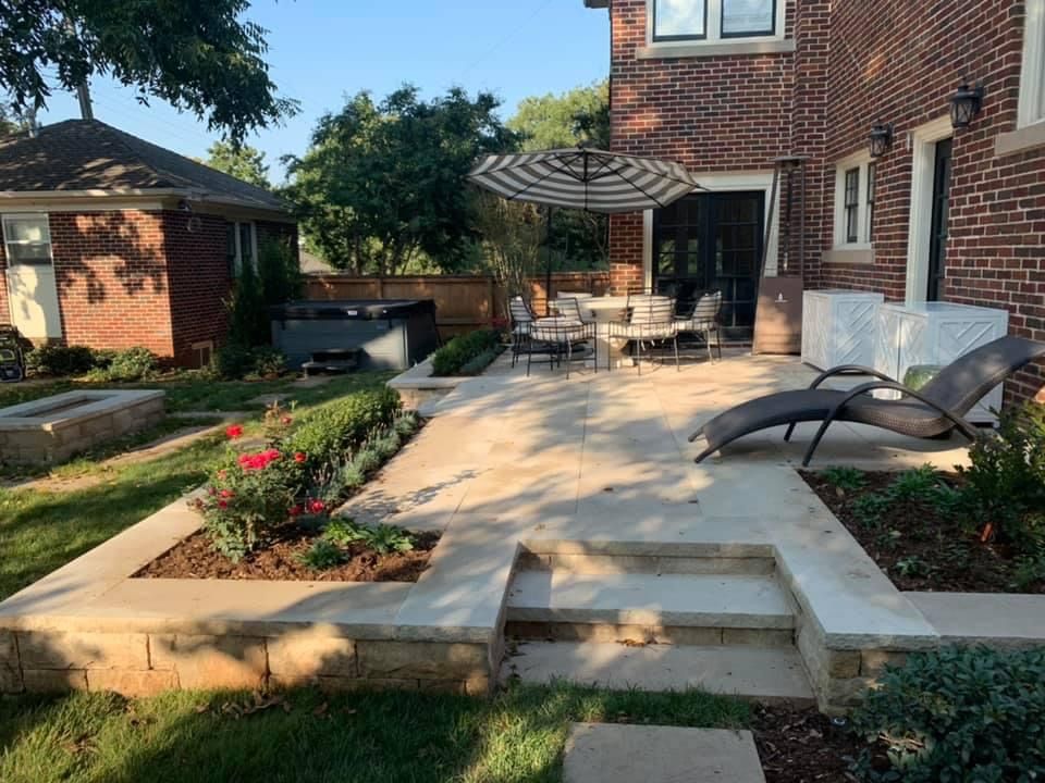 A large brick house with a patio and stairs in front of it.