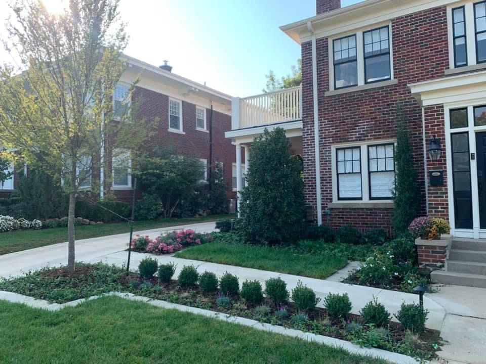 A brick house with a lush green lawn in front of it