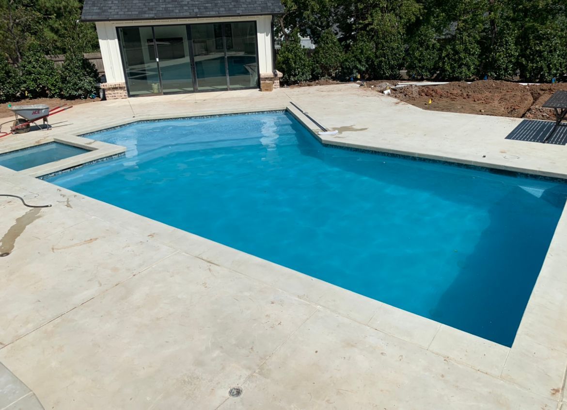 A large swimming pool with a white building in the background