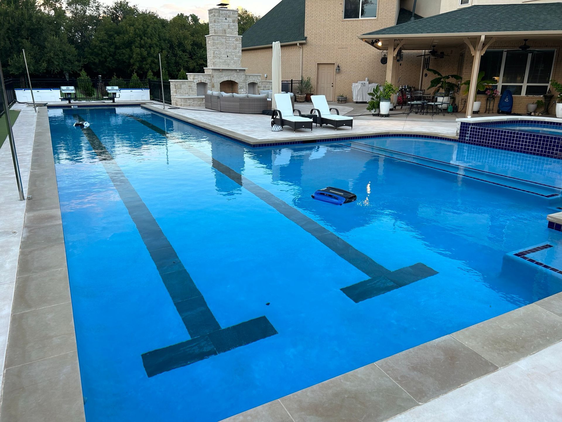 There is a large swimming pool in the backyard of a house.