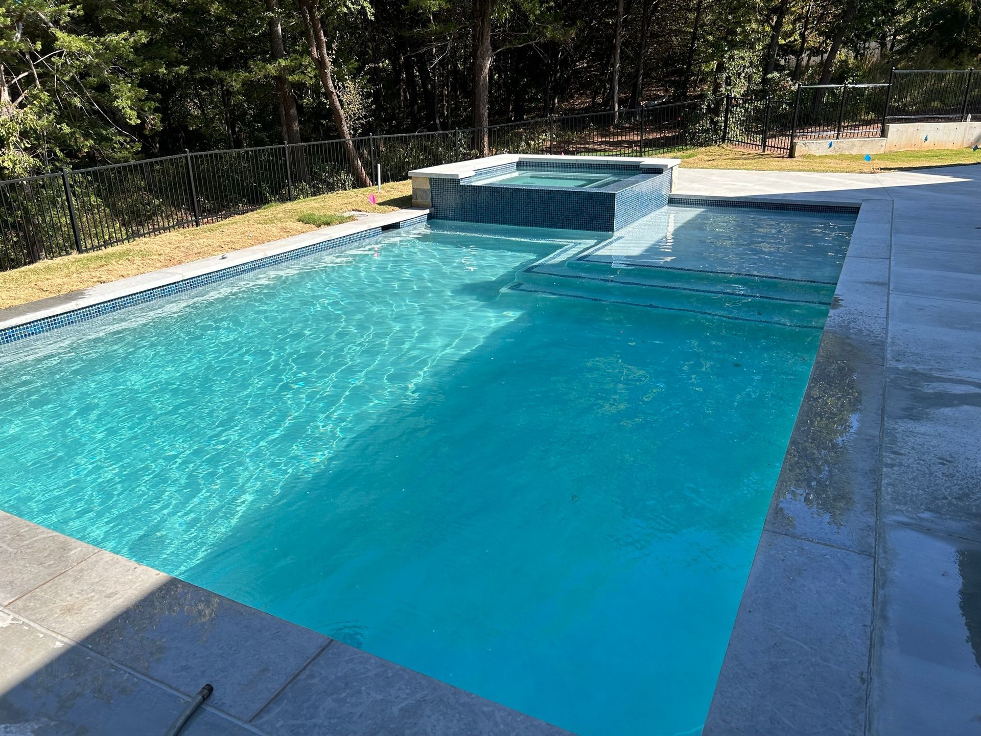 A large swimming pool with a waterfall in the middle of it.