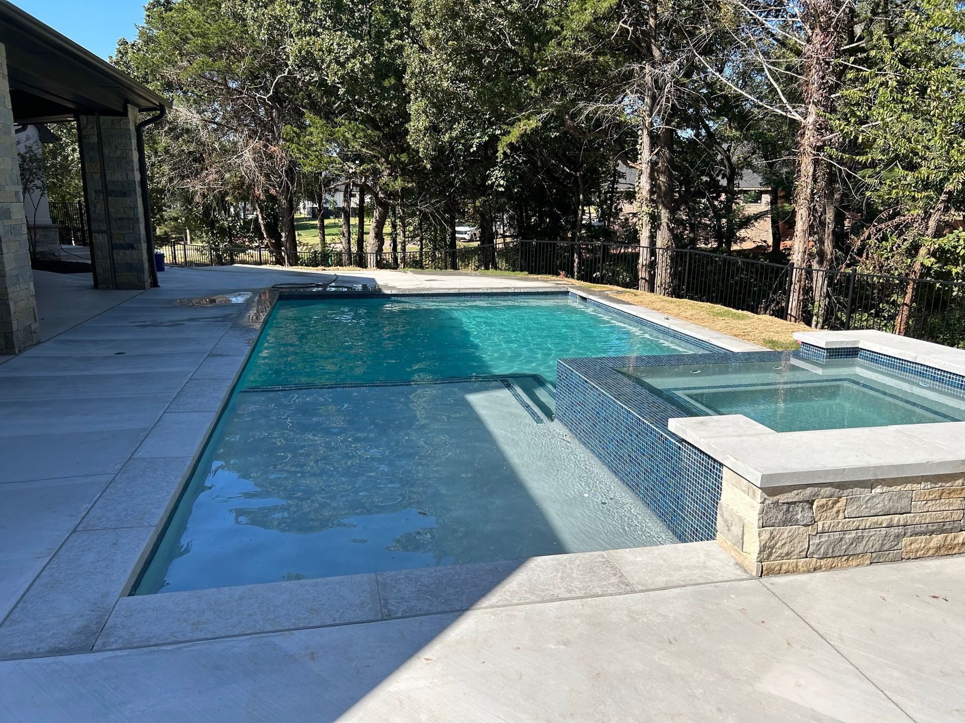 A large swimming pool with a hot tub next to it