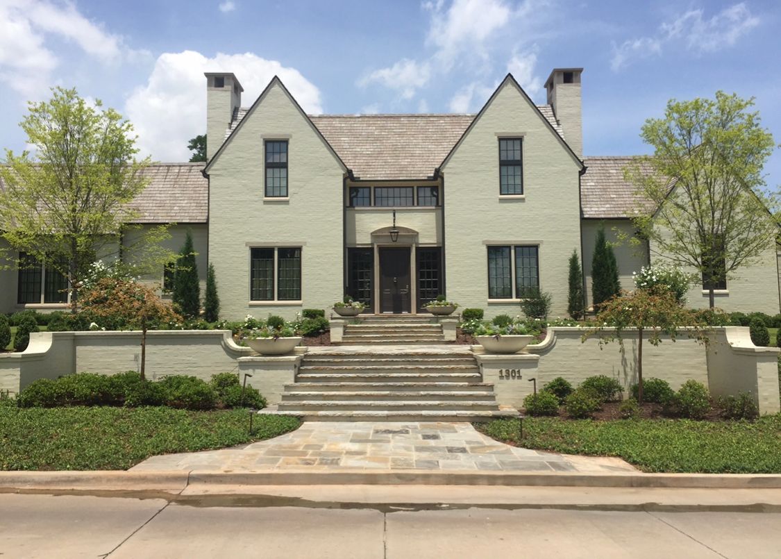 A large white brick house with stairs leading up to it