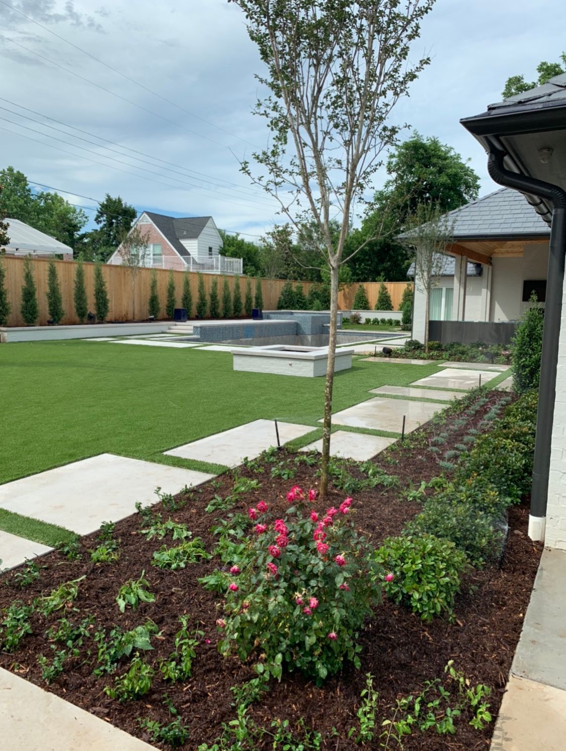 A house with a large lawn and a pool in the backyard.