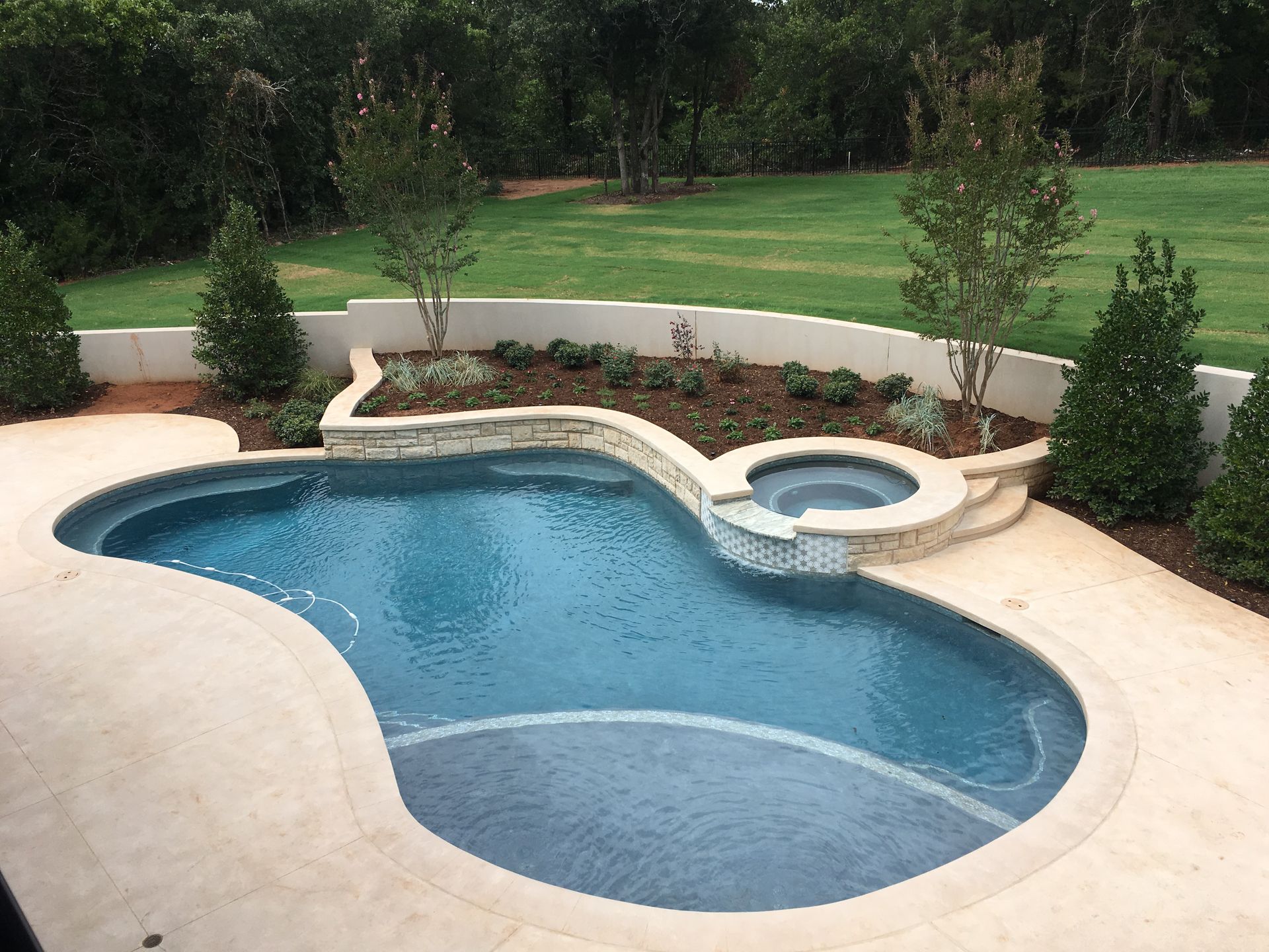 A large swimming pool with a hot tub in the middle