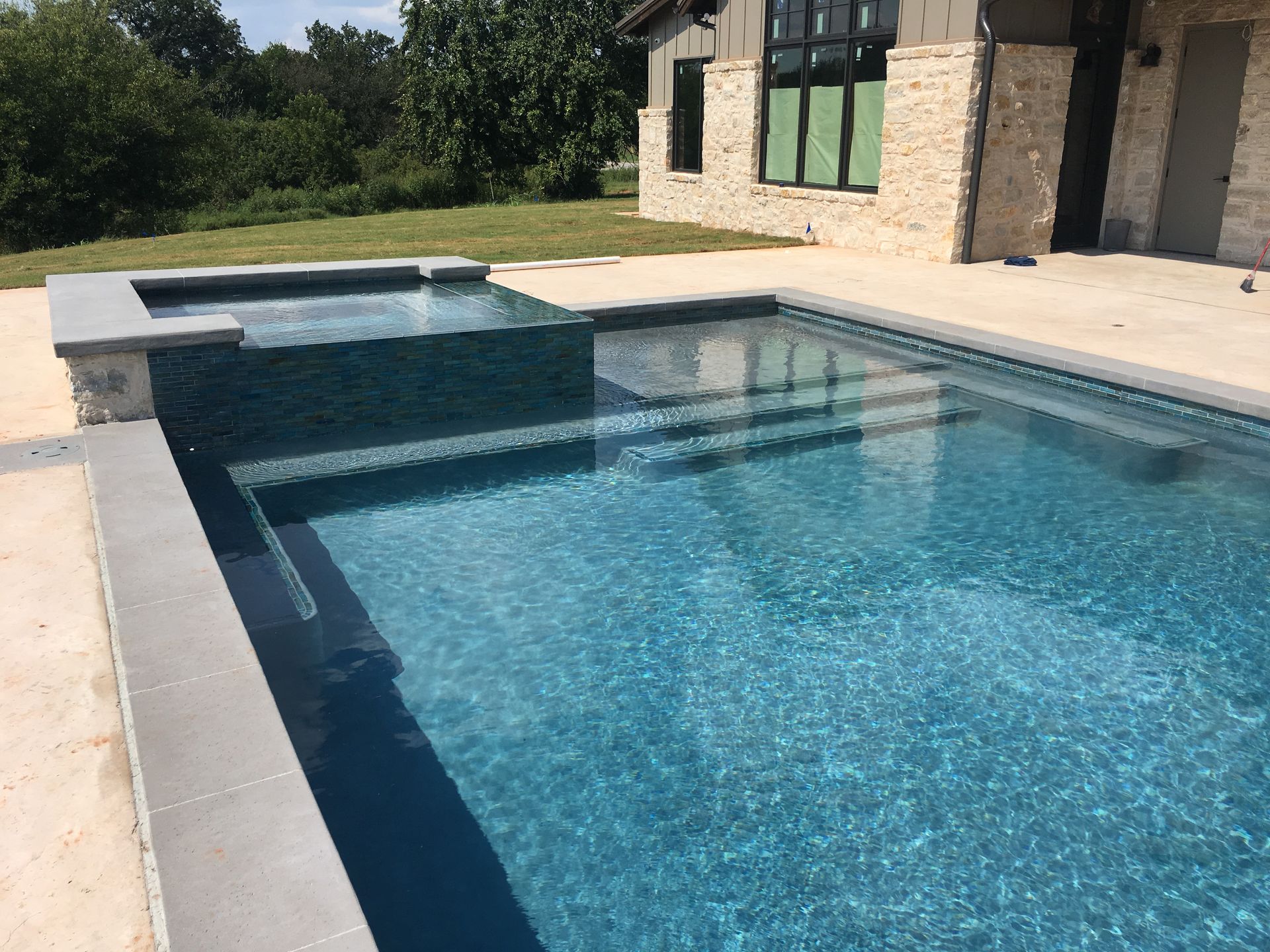 A large swimming pool with a house in the background
