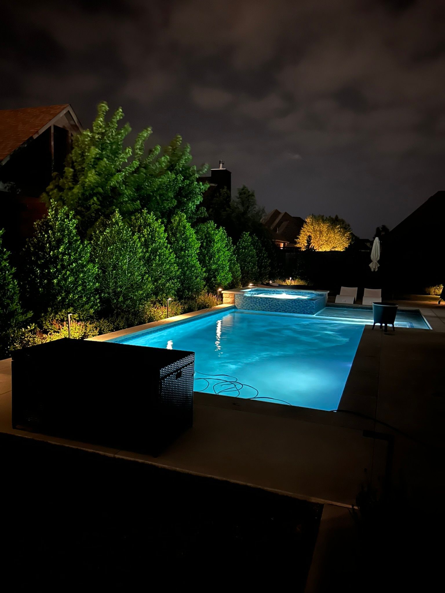 A large swimming pool is lit up at night.