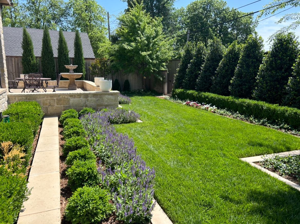 A lush green lawn with a fountain in the middle of it