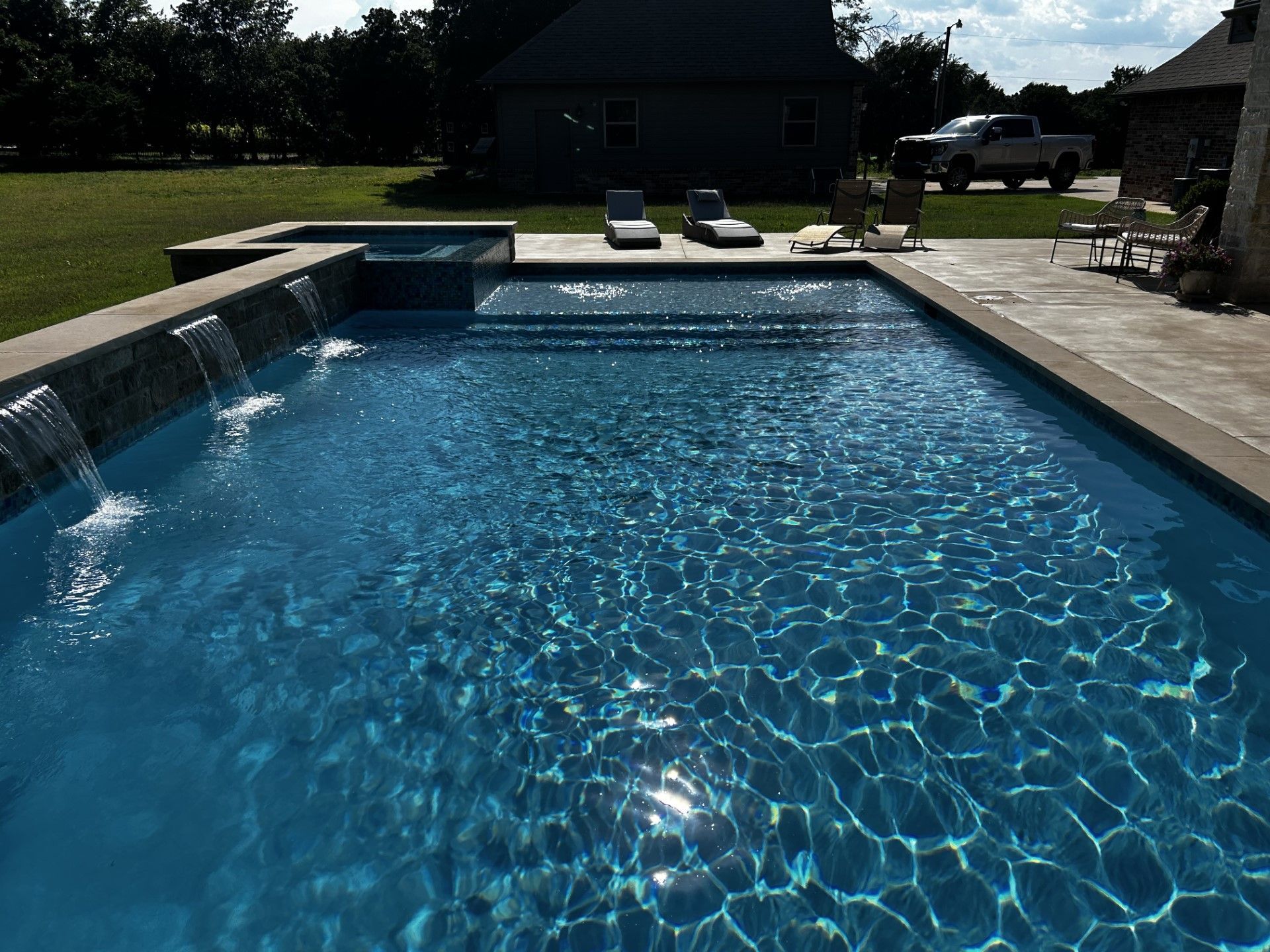 A large swimming pool with a waterfall in the middle