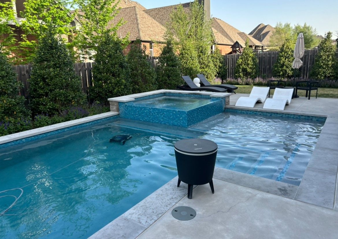 A large swimming pool with a hot tub in the backyard of a house.