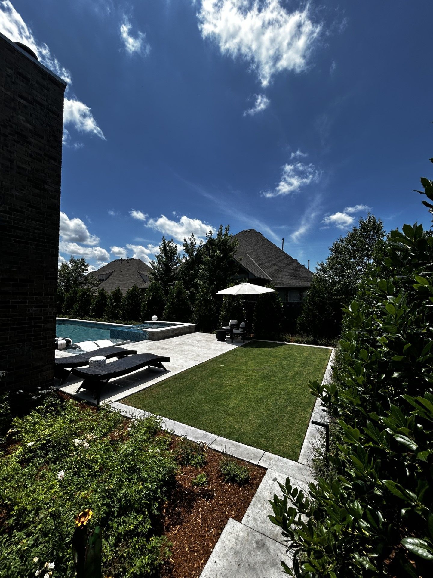 A large backyard with a swimming pool and lawn chairs