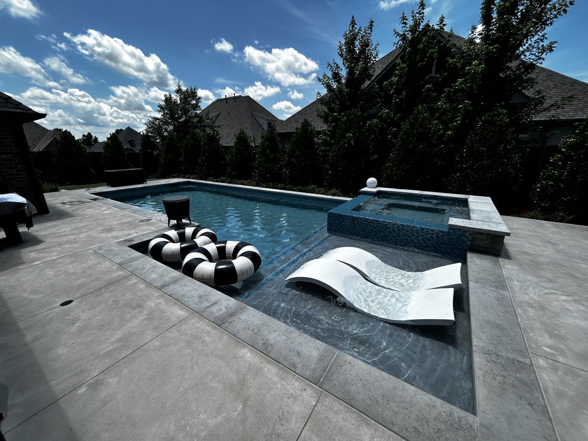 A large swimming pool with a lounge chair in the middle