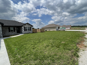 Grassy Field with Houses | Bolivar, MO | Clay Landscaping, LLC
