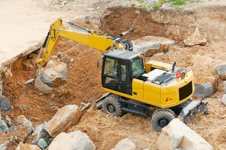 a yellow backhoe truck on the excavation