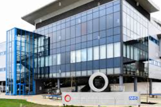 A large building with a lot of windows and a sign in front of it.