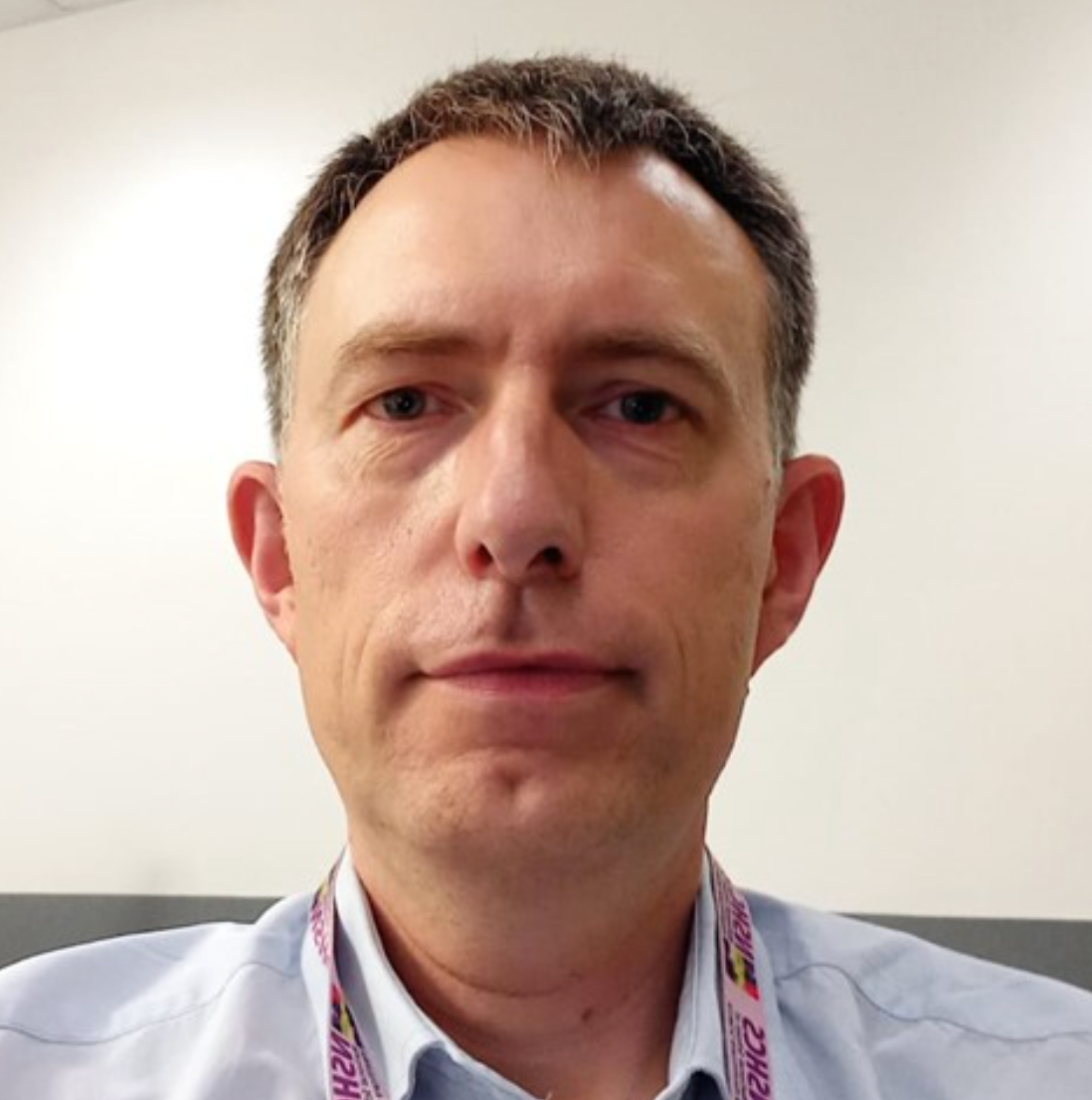 A man with a lanyard around his neck that says advice