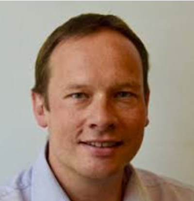 A man in a white shirt is smiling for the camera.