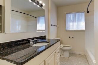 A bathroom with a sink , toilet , and mirror.