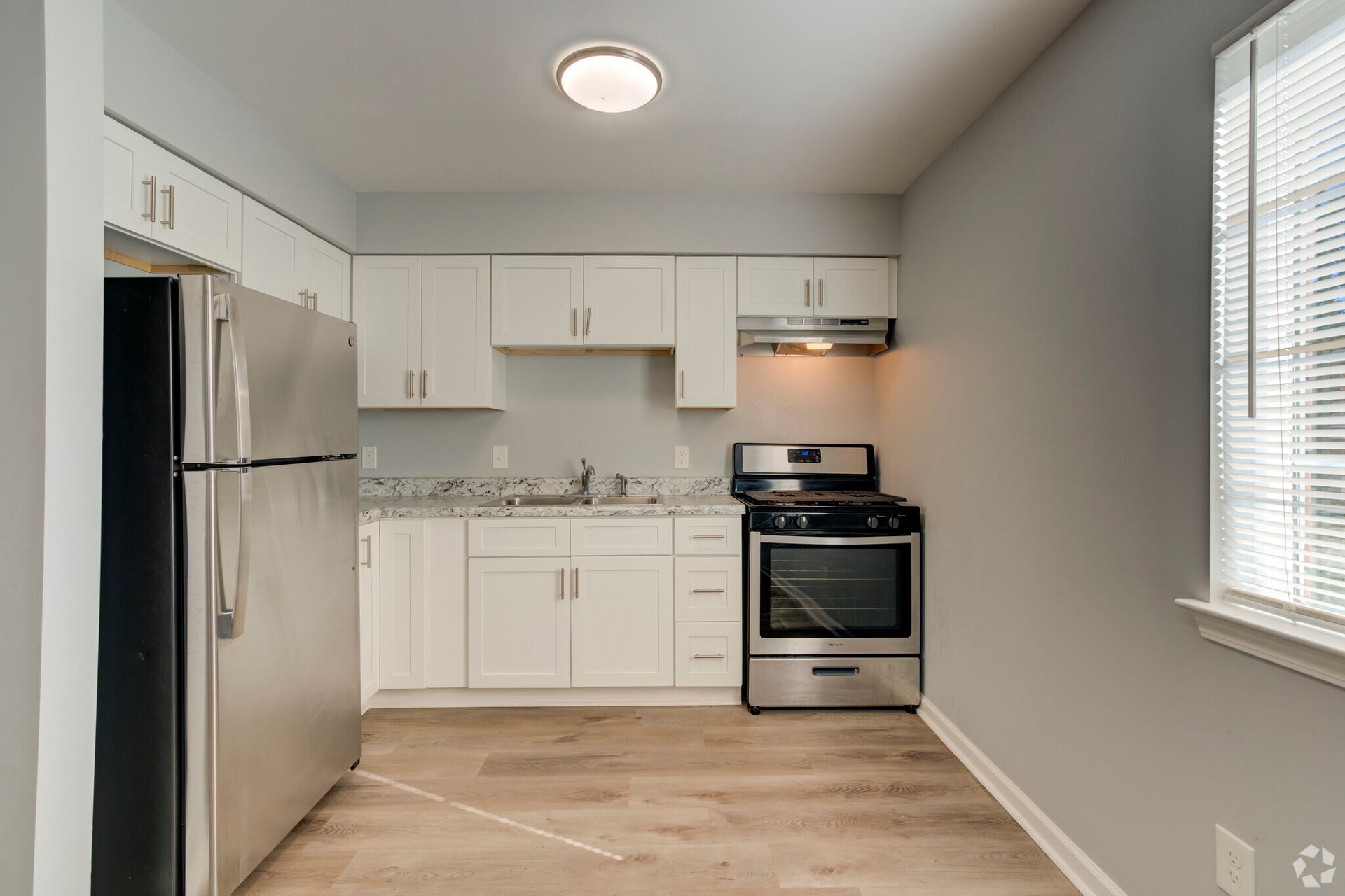 A kitchen with stainless steel appliances and white cabinets.