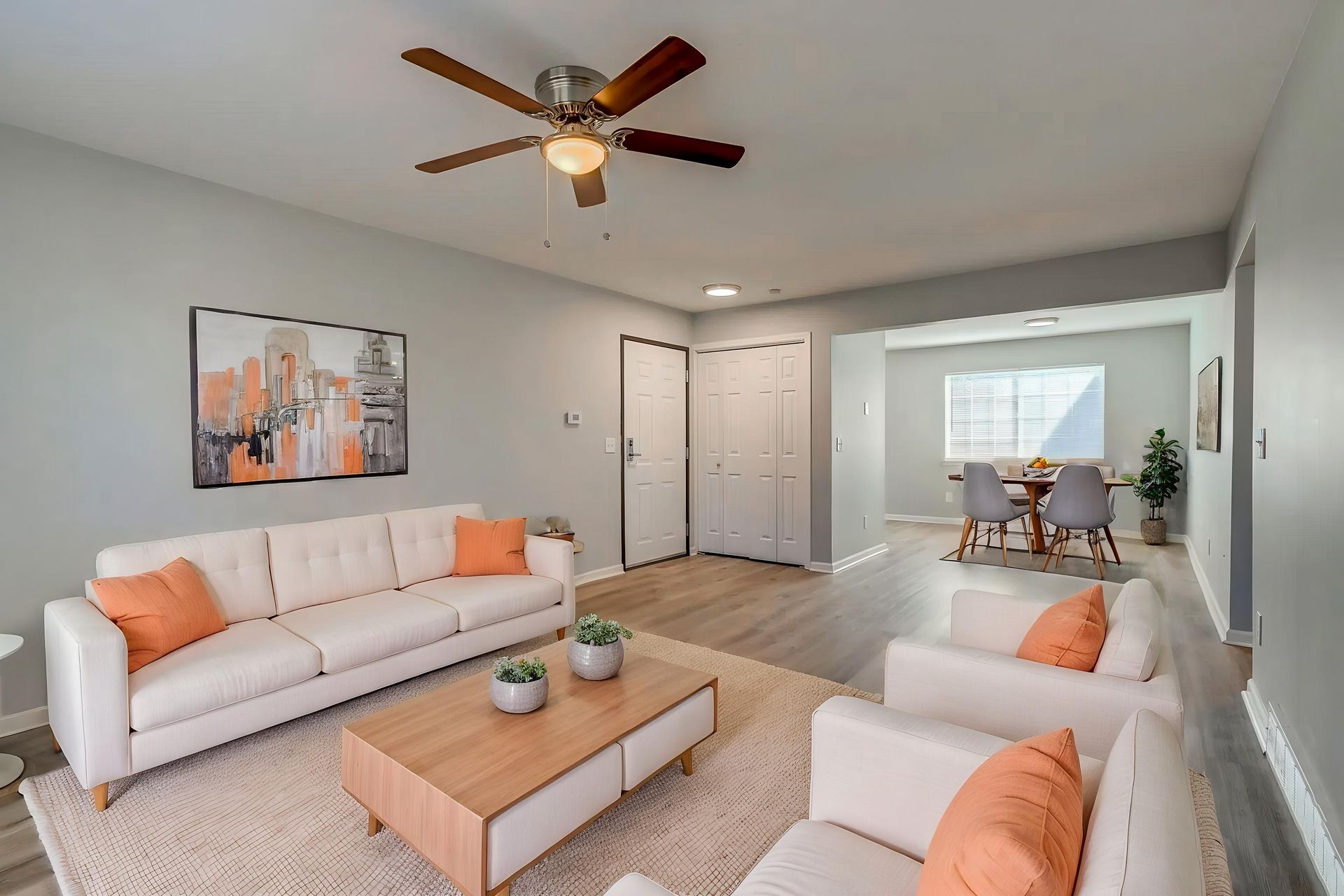 An empty living room with hardwood floors and a ceiling fan.