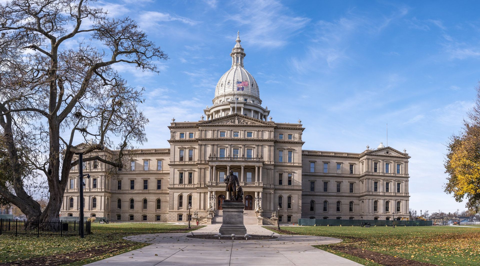 A large building with a dome and a statue in front of it.