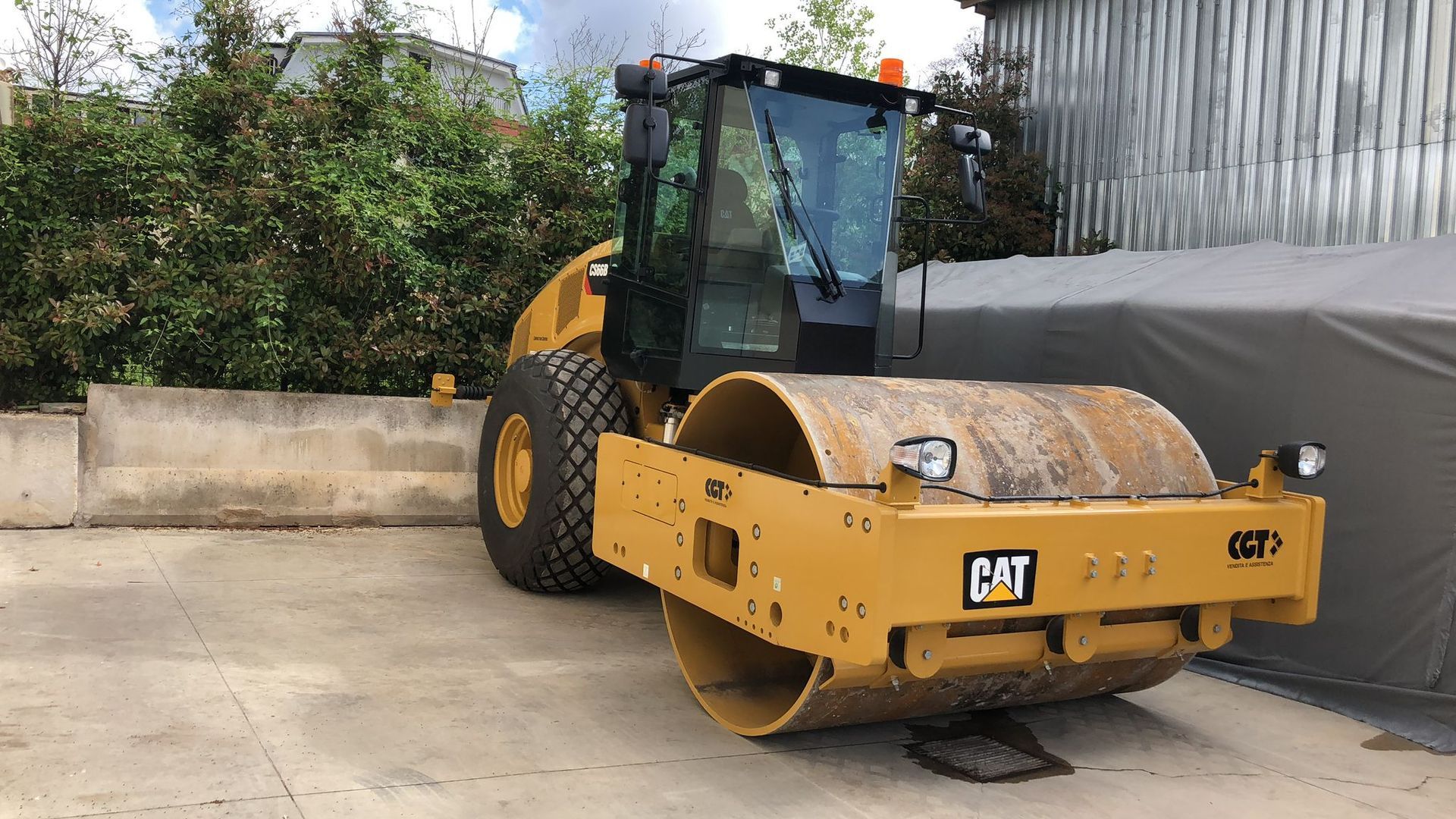 Un rullo compressore giallo è parcheggiato in un parcheggio.