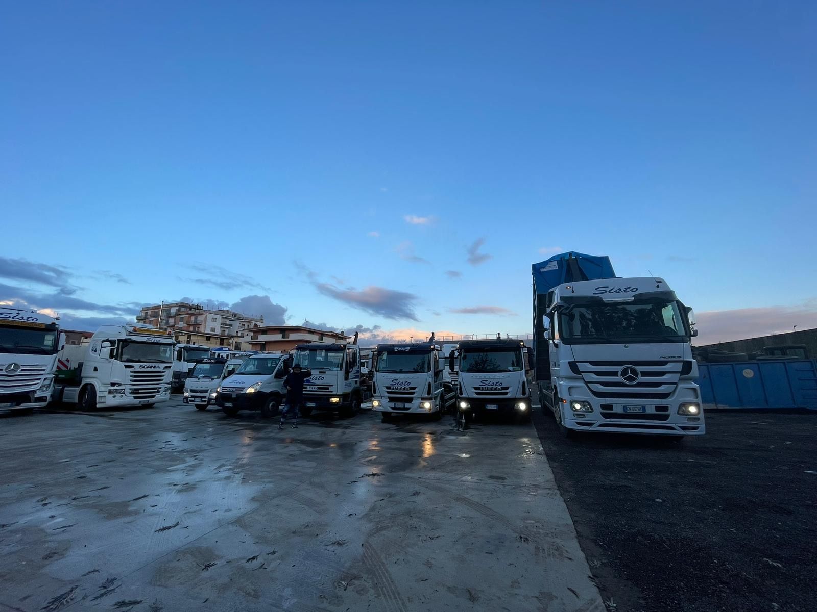 Una fila di camion bianchi sono parcheggiati in un parcheggio.