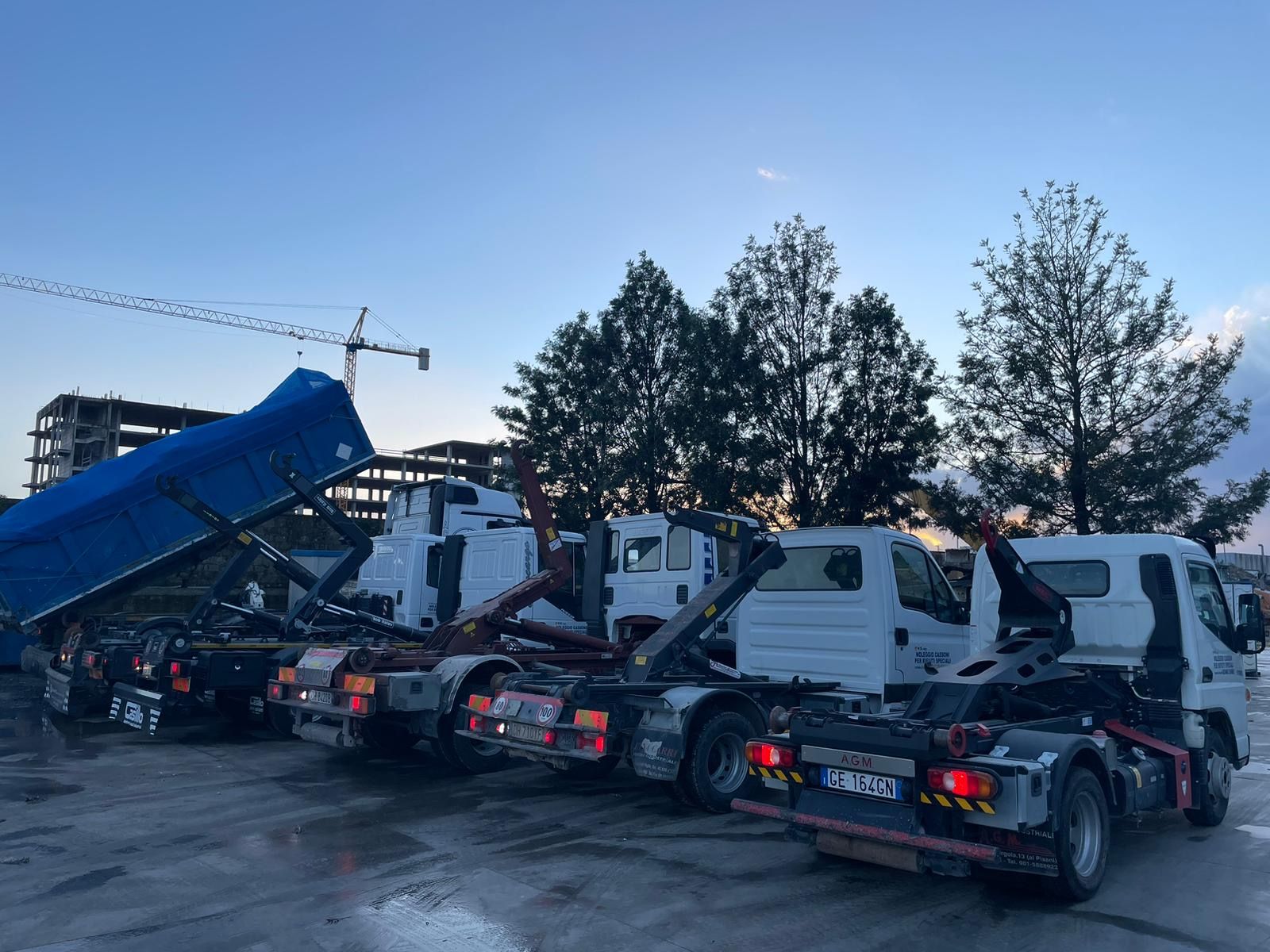 Una fila di autocarri con cassone ribaltabile sono parcheggiati in un parcheggio.