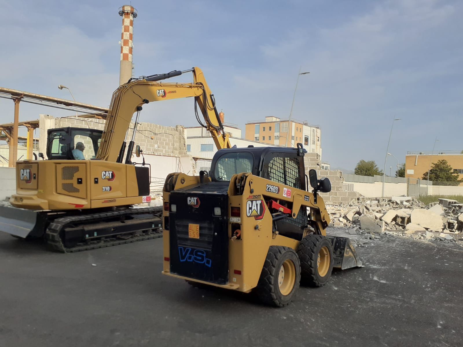 Due veicoli da costruzione sono parcheggiati sul ciglio della strada.