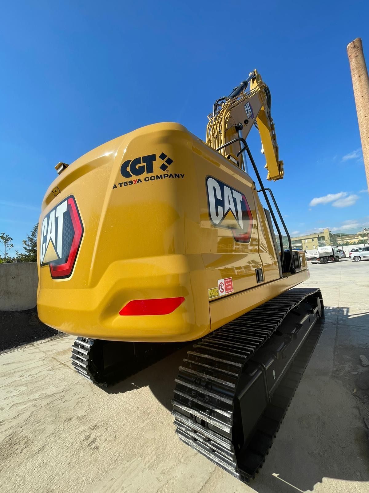 Un escavatore giallo è parcheggiato in un parcheggio.