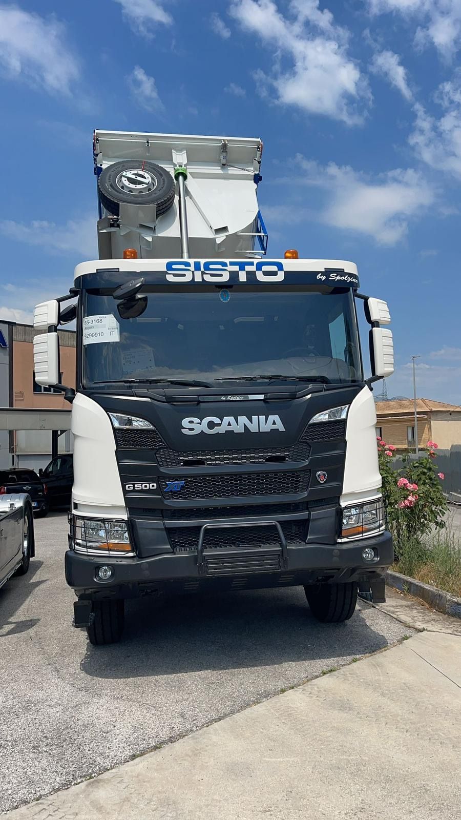 Un camion Scania bianco e nero è parcheggiato sul ciglio della strada.