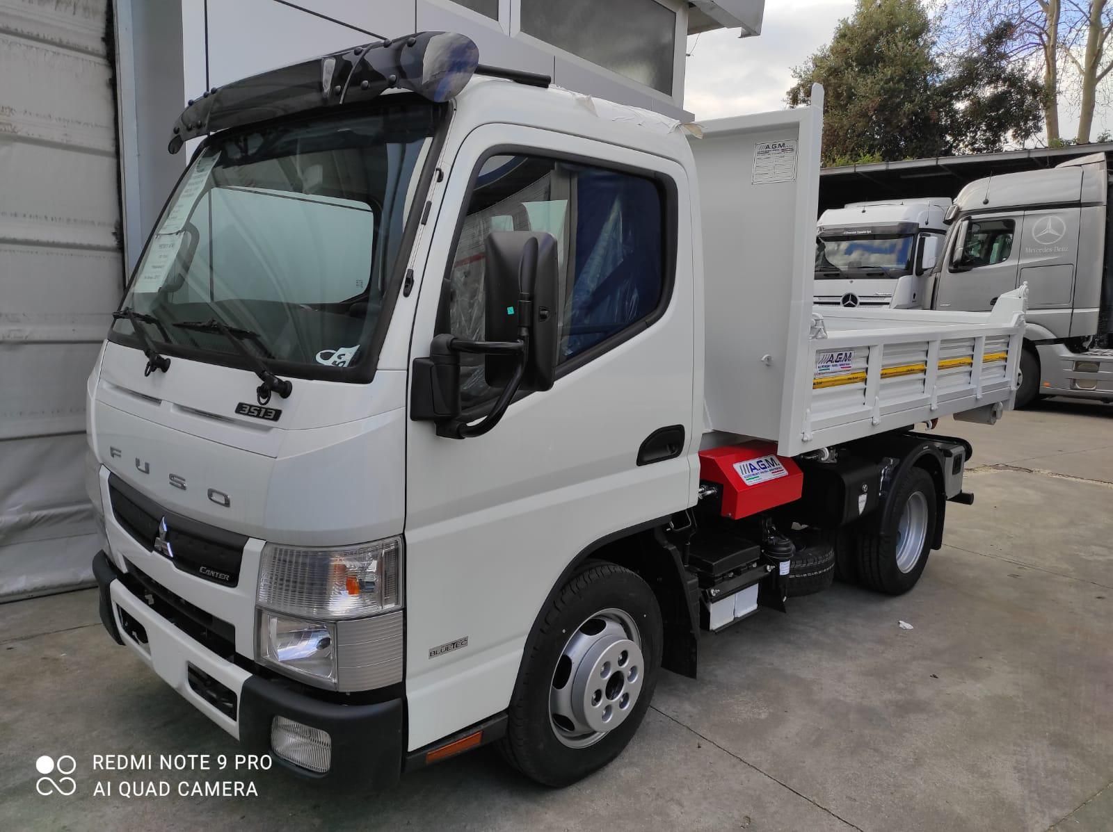 Un camion bianco è parcheggiato davanti a un edificio.