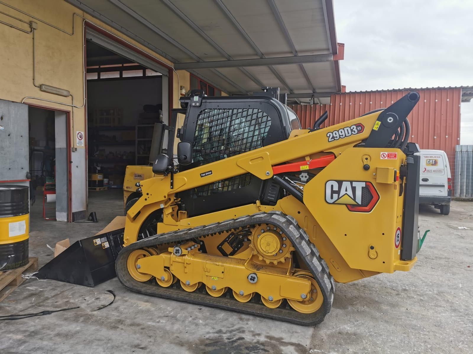 Un bulldozer giallo è parcheggiato davanti a un edificio.