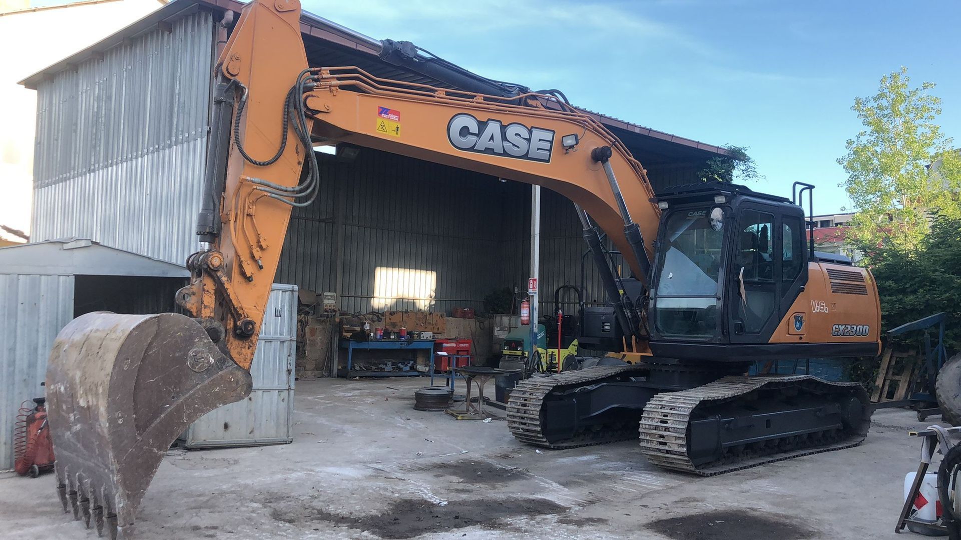 Un escavatore è parcheggiato davanti a un edificio.