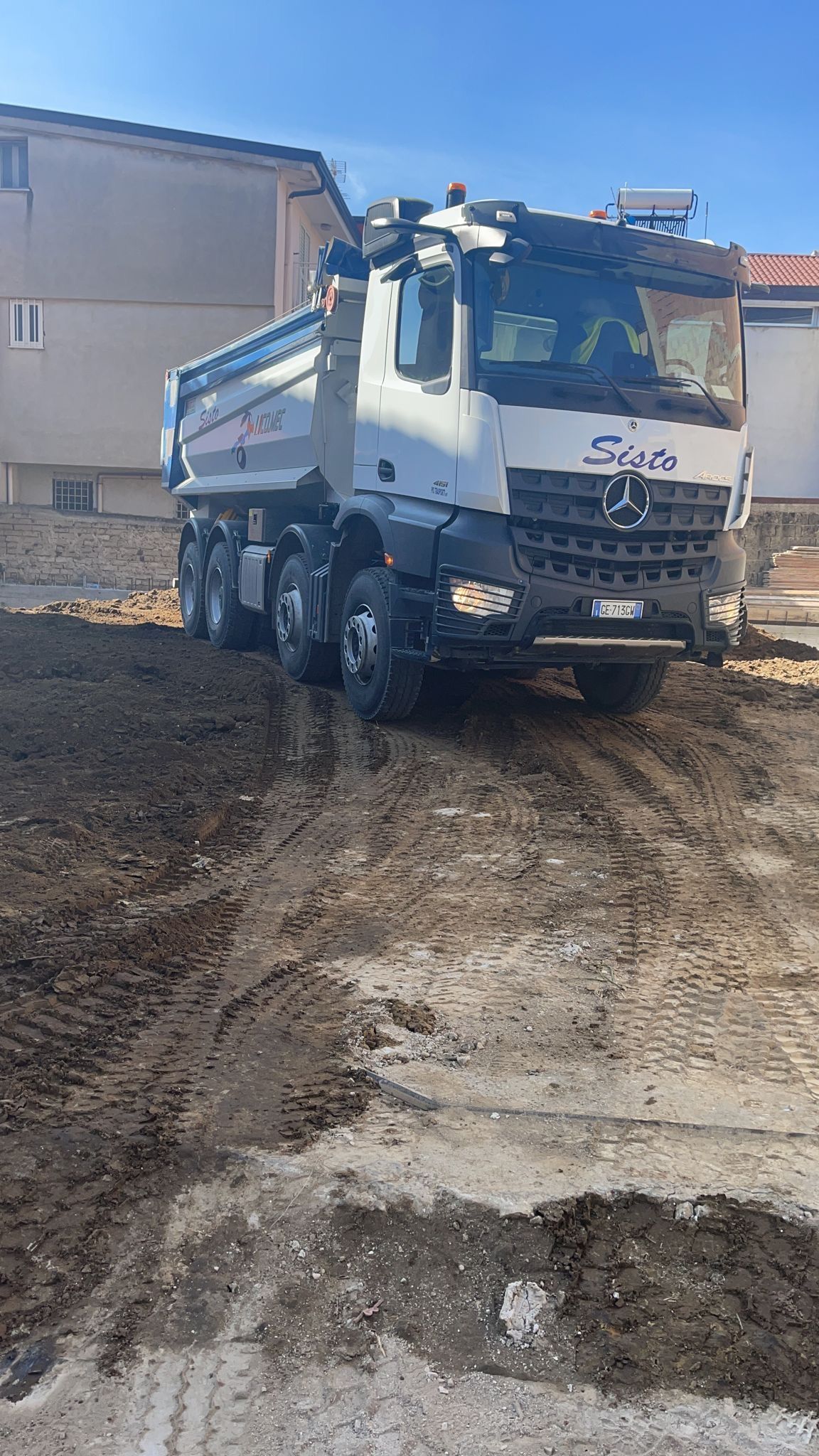 Un autocarro con cassone ribaltabile sta attraversando un campo sterrato.