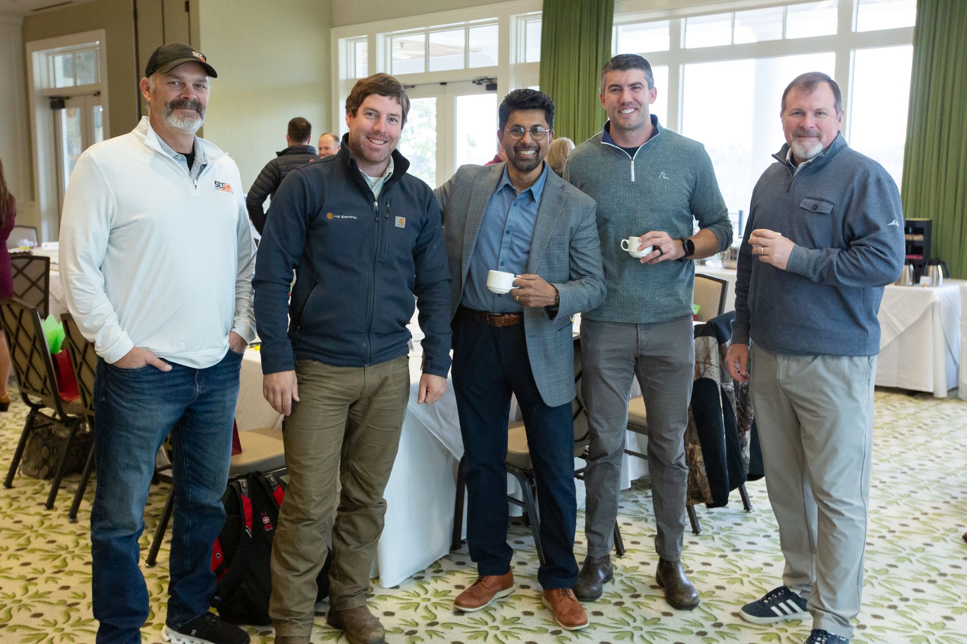 two men are looking at sticky notes on a glass wall .