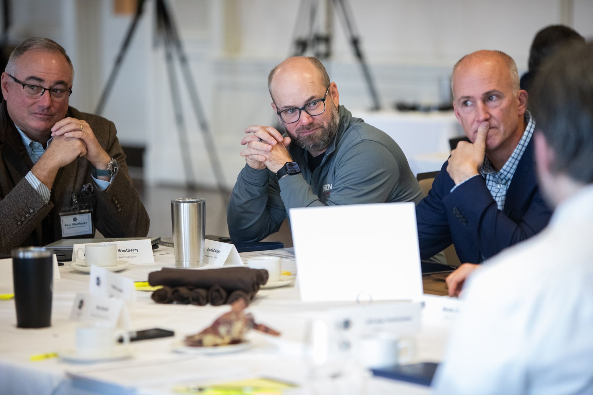 two women are standing at a standing desk in front of a computer .